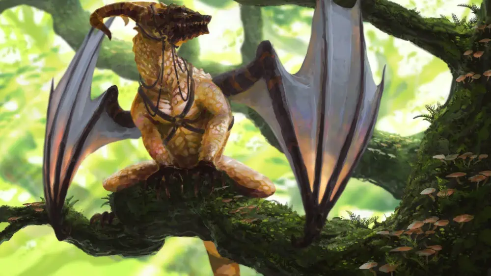 A tan dragon with a dark brown face and paws wears a leather harness while it sits on a tree branch and looks up and to the right. Behind it are bright green leaves and more branches.